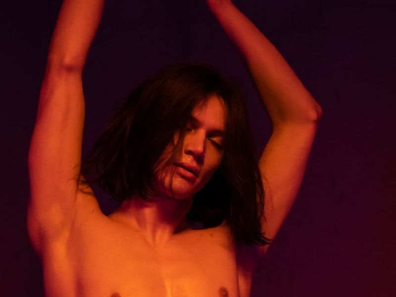 Person performing a fluid stretching movement in a minimalist room.