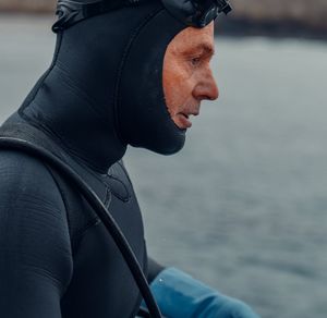 Side profile of a person taking a deep breath outdoors.